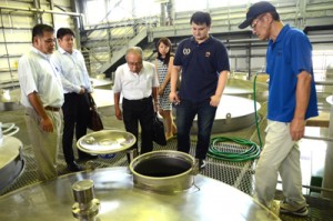 焼酎工場を見学するロブションさん（右から２人目）ら＝２２日、龍郷町