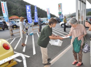 買い物客にチラシを配布するノイヌ・ノネコ対策検討会の会員ら＝２１日、奄美市名瀬