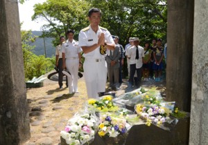 合掌して犠牲者の冥福を祈る参列者＝４日、奄美市