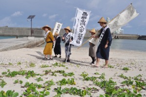 上陸地の伊延の浜を出発する西郷隆盛役と役人役の一行＝９日、和泊町伊延