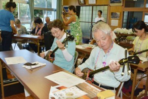 三味線体験や集落散策があったサンセットバスツアー＝８日、瀬戸内町