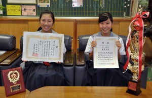 【写真説明】ヨコ 県内中学校の英語暗唱大会で最優秀賞を受賞した屋舞美さん（右）と英語弁論大会で２位になった森悠里さん（左）＝１４日、名瀬中学校