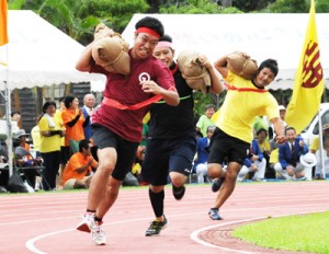 迫力のレースを繰り広げた「俵運搬」＝９日、宇検村総合運動公園陸上競技場