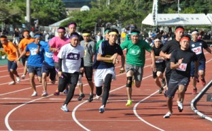 小学生から６０代までが力走した男子年齢別８００㍍リレー＝１３日、名瀬運動公園陸上競技場