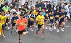 一斉にスタートする２㌔の出場者たち＝２７日、名瀬運動公園クロスカントリーコース