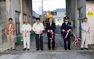 テープカットをして製糖期間中の安全操業を祈願した生和糖業の原料輸送出発式＝１８日、喜界町