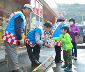 赤い羽根共同募金の街頭活動を行うボランティアら＝３日、奄美市名瀬