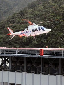 出動待機のため、県立大島病院救命救急センター屋上ヘリポートに着陸する奄美ドクターヘリ＝２７日午前８時すぎ、奄美市名瀬