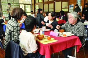 地域住民と一緒に食事を味わう児童ら＝２４日、住用小学校