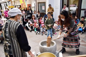 餅つきを楽しむ来場者ら＝２８日、奄美市名瀬