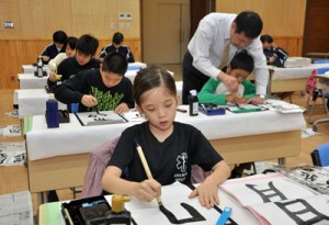 集中して筆を運ぶ児童生徒＝６日、大和村防災センター