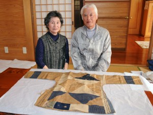 ノロの胴衣などを大切に保管している叶純宜さん、房代さん夫妻＝１７日、奄美市名瀬