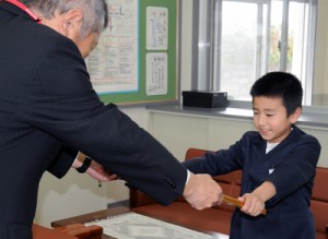 優秀賞に選ばれ、賞状を受け取る平島颯大君＝２日、奄美市の屋仁小学校