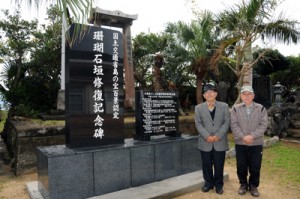 建立した「珊瑚石垣修復記念碑」前に立つ与路珊瑚石垣保護組合の（左から）福島組合長、福山副組合長＝１３日、与路島