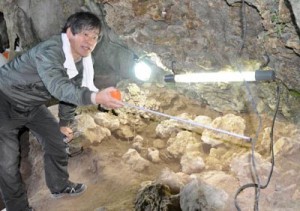 下原洞穴遺跡で発見された石棺墓を調査する竹中教授（上）と、石鏃を製作する道具や石材＝３０日、天城町