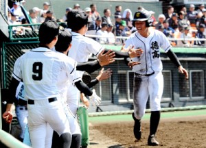 先制のホームを踏んでベンチに迎えられる徳之島の澤村＝４日、鴨池野球場