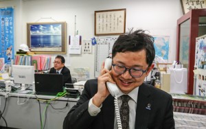 電話応対にも意気込みがあふれている隈元さん＝１１日、奄美市東京事務所