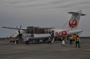 奄美空港に就航したＪＡＣの新型機と搭乗客ら＝２８日、奄美市笠利町