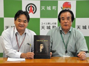 さいごうウオーク推進事業を活用して発行した記念誌「西郷南洲翁と徳之島」と担当者ら＝２日、天城町役場