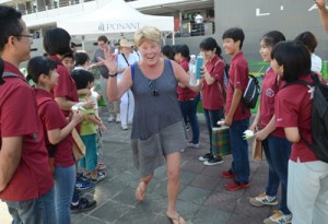 生徒から折り紙を贈られて笑顔を見せる乗客＝４日、奄美市名瀬