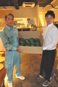 奄美パパイアのＰＲに向けて、果実を提供する熊元部会長（左）＝１９日、徳之島町亀津