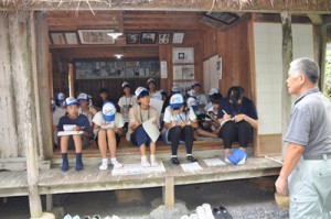 西郷南洲謫居跡で説明を受ける参加者＝２８日、龍郷町