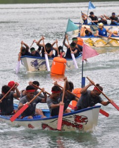 男子決勝で力強いかいさばきを見せる舟こぎの選手たち＝２３日、龍郷町