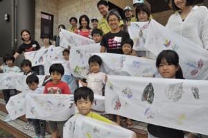 自分で作った葉っぱプリント手ぬぐいを広げる子どもたち＝３１日、大和村の奄美野生生物保護センター