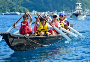 伴走船に見守られながら板付け舟での海峡横断に挑戦した生徒たち＝３０日、瀬戸内町  