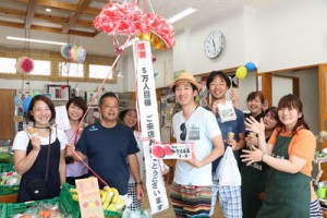 ５万人目の来場者となった藤井誠さん（中央）と祝福する関係者ら＝１２日、瀬戸内町瀬相（提供写真）