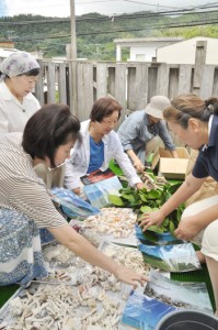 「奄美箱」に詰め込む品々を準備する奄美虹の会メンバー＝１日、奄美市名瀬