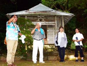 参加者に境内からの眺望の魅力を説明する東川さん（左）＝２１日、宇検村宇検の高千穂神社