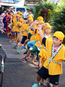 恒例の「子ども種おろし」。地区内を歌い踊り歩く子どもたち＝１９日、龍郷町中戸口