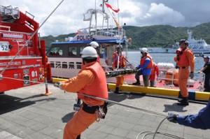 漂流者救助の患者引き継ぎ訓練を行う警察と消防署員ら＝２７日、奄美市名瀬観光船バース