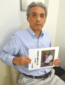 祖父武重さんの戦争体験記を手にする平田さん＝２日、鹿児島市