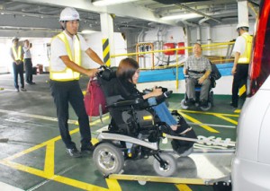 デモンストレーションで車いすのまま福祉車両に乗り込む利用者＝１日、鹿児島市の鹿児島新港