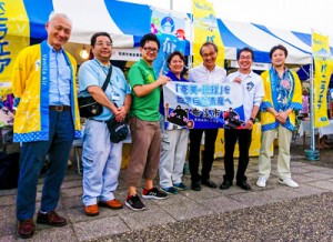 椎名山武市長（右から３人目）が奄美市のブースに来場し、交流拡大に期待した＝７月２９日、千葉県山武市