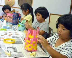 あみかご作りに取り組む児童＝２３日、瀬戸内町立図書館・郷土館