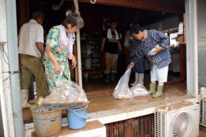 床上浸水で泥水に漬かった家屋内の片付け作業に追われる住民ら＝５日午後２時４５分ごろ、喜界町小野津