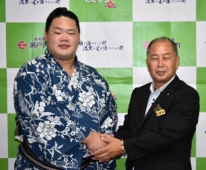 鎌田町長（右）と握手をする明生関＝２６日、瀬戸内町