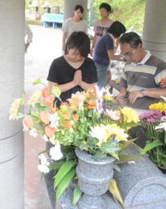 送り盆。精霊殿で祖霊に手を合わせる人々＝５日、宇検村田検集落の共同納骨堂