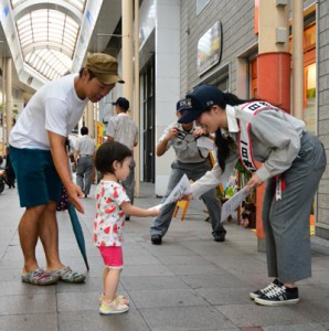 チラシを配って救急車の適正利用を呼び掛ける碩さん（右）＝８日、奄美市名瀬