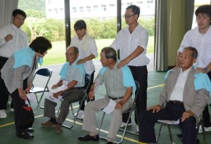 来場者にマッサージをするこども・かいご福祉学科の学生ら＝８日、奄美看護福祉専門学校