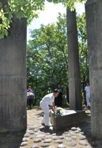 献花して犠牲者の冥福を祈る参列者＝１０日、奄美市