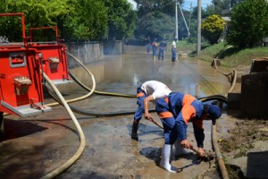 志戸桶地区の町道冠水場所での側溝の土砂撤去と路上の排水作業＝６日、喜界町