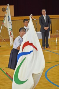 パラリンピックの旗振り体験をする児童＝２０日、名瀬小学校