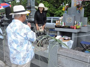 墓地にシバを飾り、先祖に手を合わせる住民＝１日、喜界島小野津の共同墓地