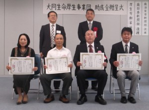 助成を受けた瀬利覚福祉部の栗尾代表（前列左）ら県内４団体（提供写真）