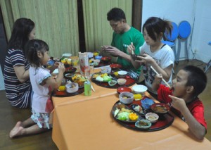 オープンした子ども食堂の料理を食べる親子連れ＝１４日、徳之島町亀津