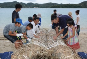 草船の船体を作る参加者ら＝１４日、奄美市笠利町